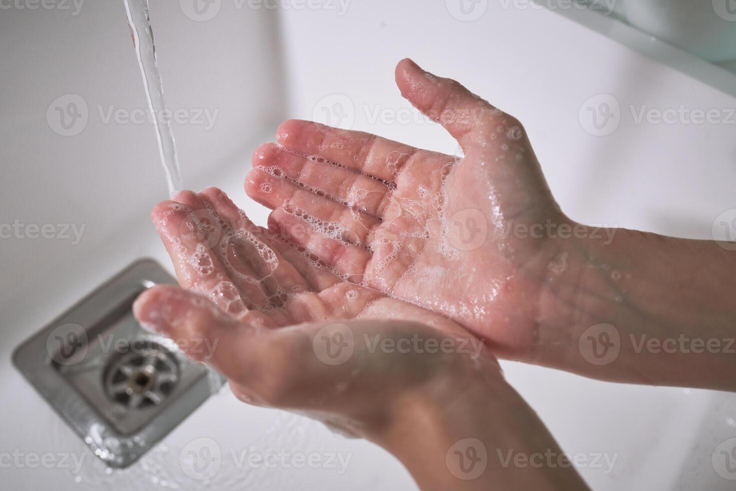 Anonymous kid washing hands with soap photo