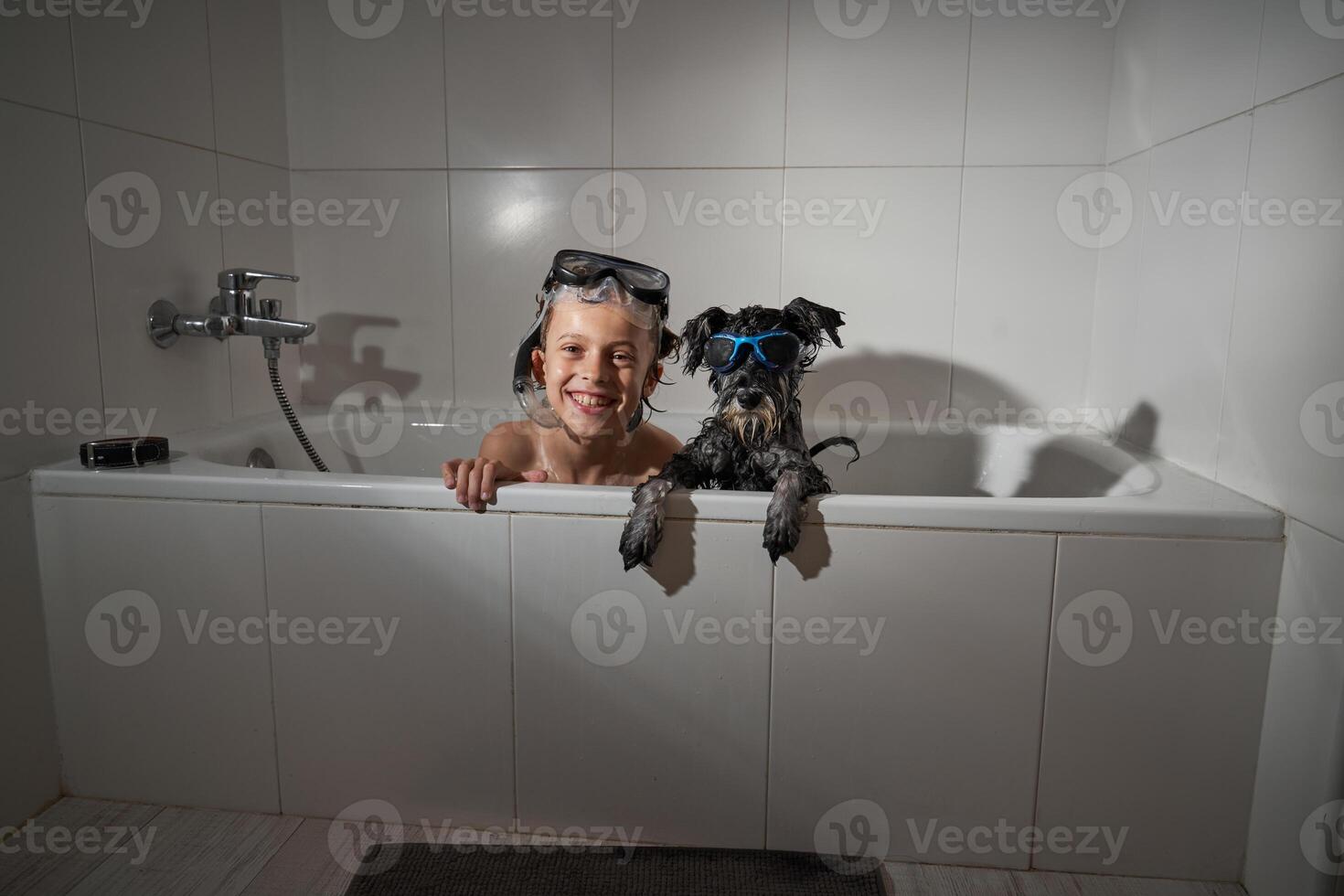 Delighted boy with dog in tub photo