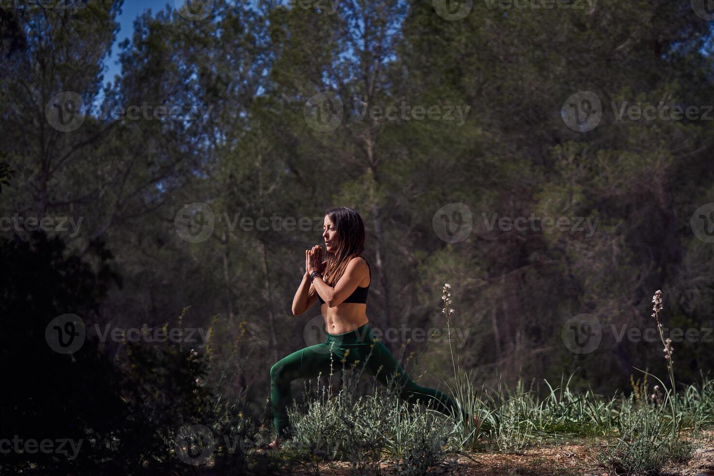 Fit ethnic female practicing Crescent Lunge with Prayer Hands po photo