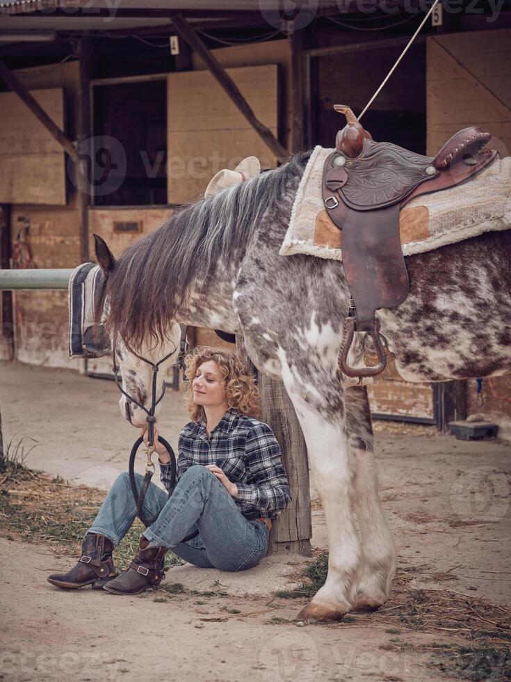 Woman with horse in paddock photo