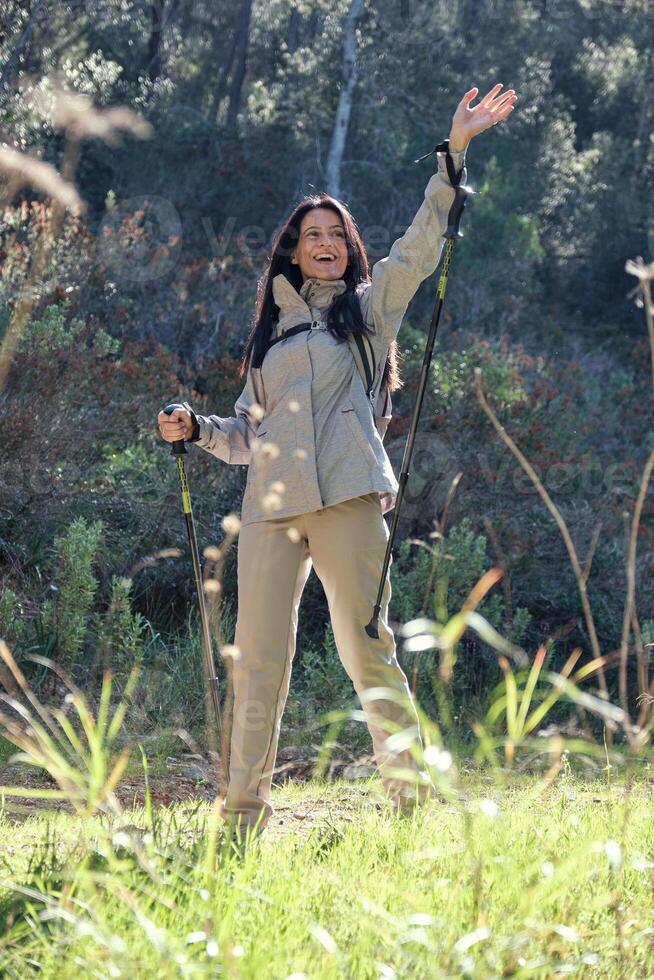 Hispanic woman waving hand during hiking photo