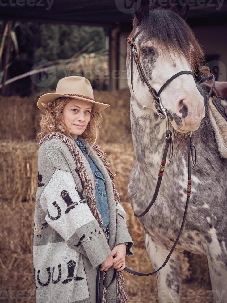 Adult female equestrian holding purebred horse by reins photo