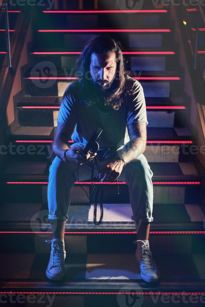Man with headphones on steps in club photo