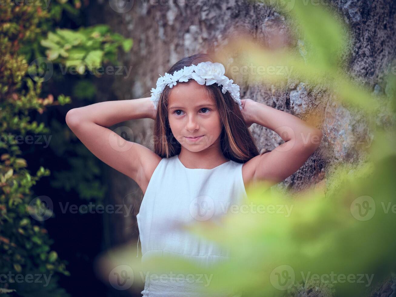 Pretty girl in white wreath touching head while standing near ol photo