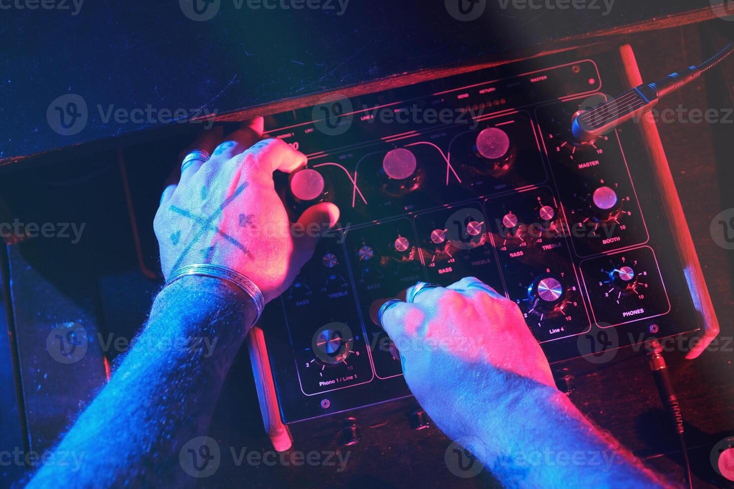 Unrecognizable DJ playing on audio mixer photo