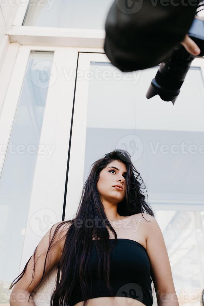 Crop photographer taking pictures of young model photo
