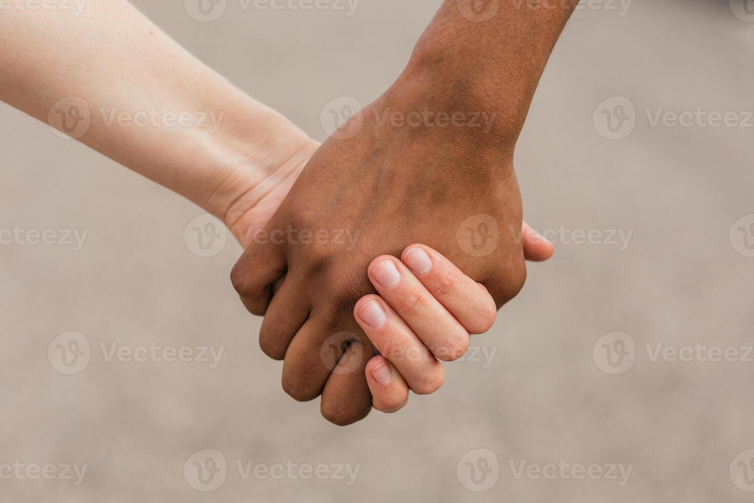 Multiethnic best friends holding hands tenderly photo