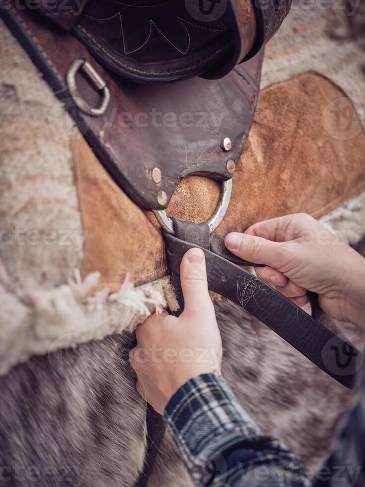 Anonymous rider tying knot on girth photo