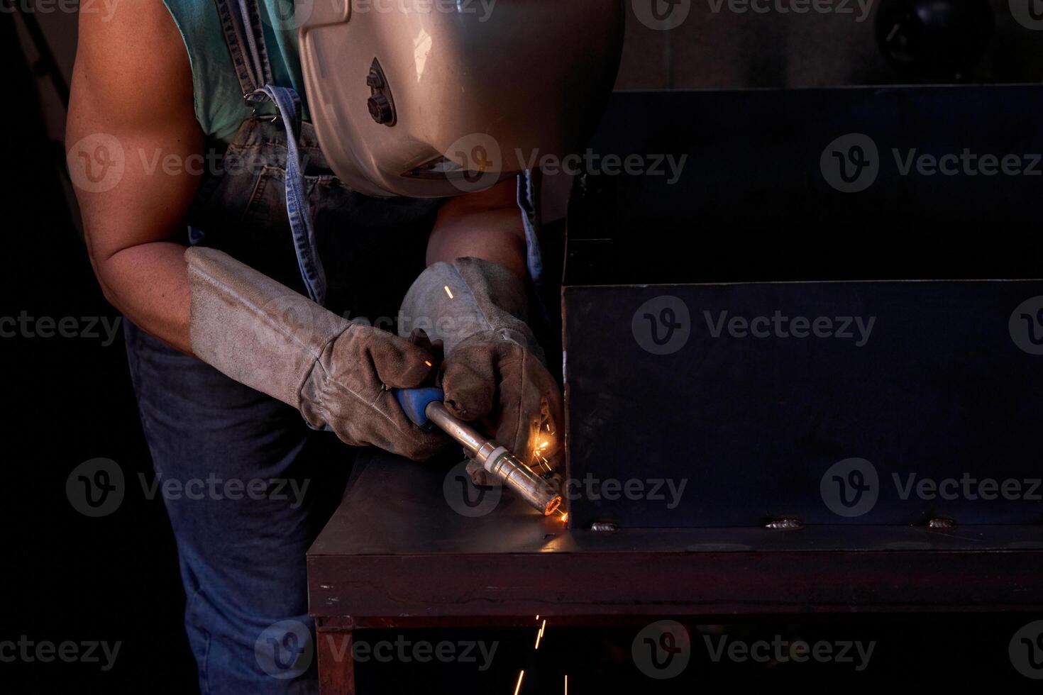 Anonymous man welding metal structure photo