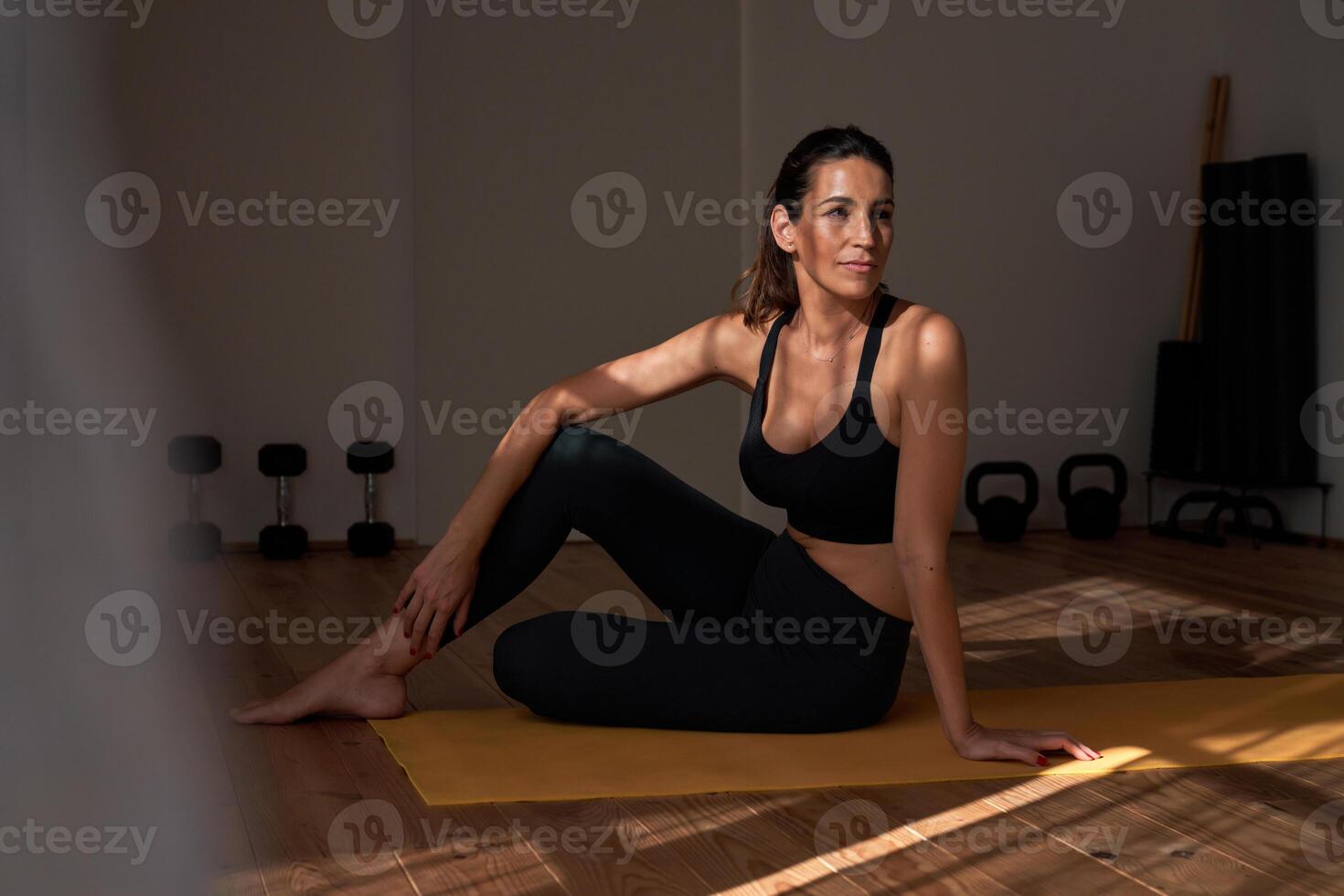 Adult sportswoman resting after workout in modern gym photo