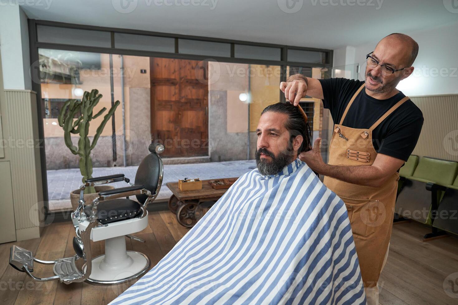Barber combing hair of client in salon photo