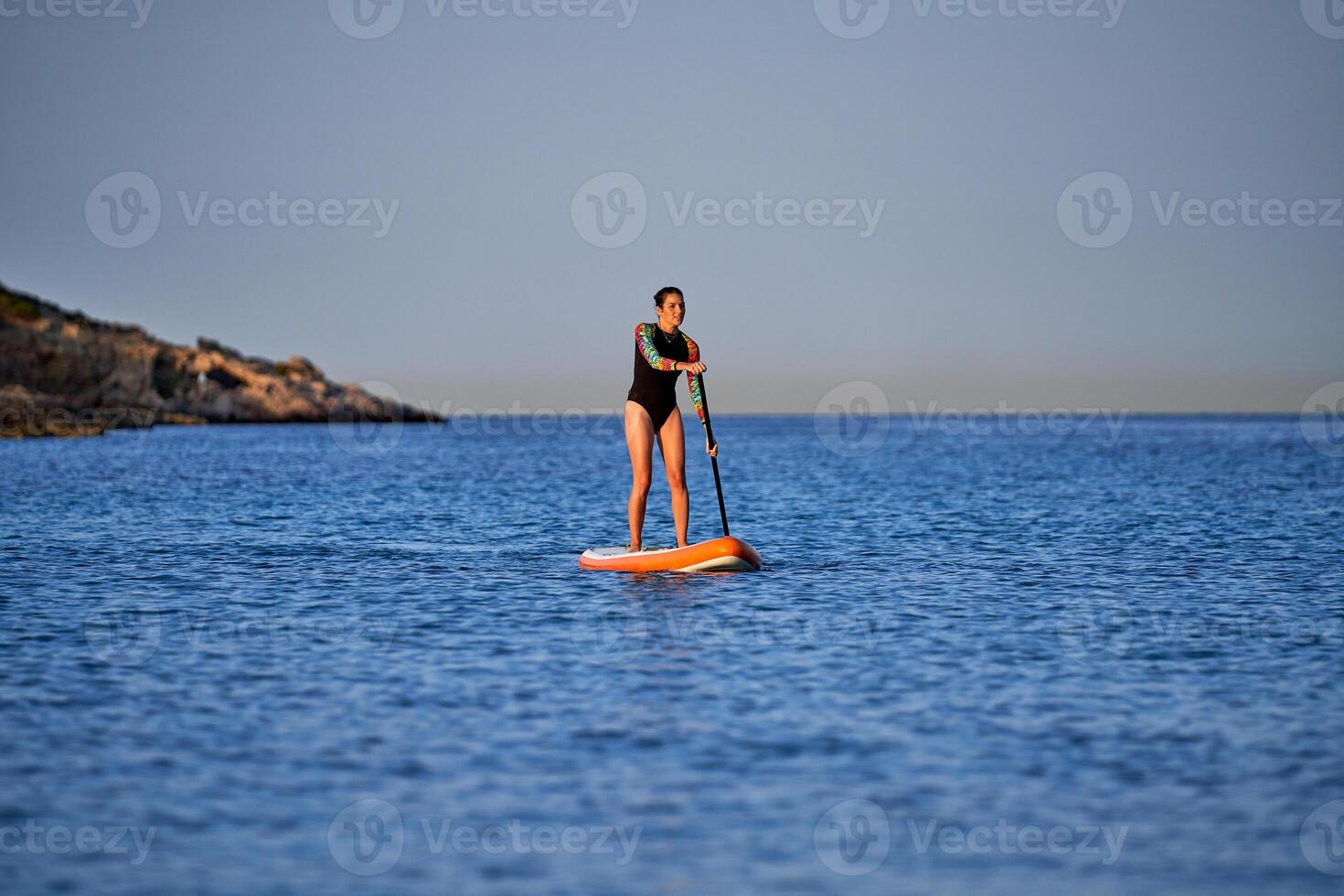 Fit woman on paddleboard in sea photo