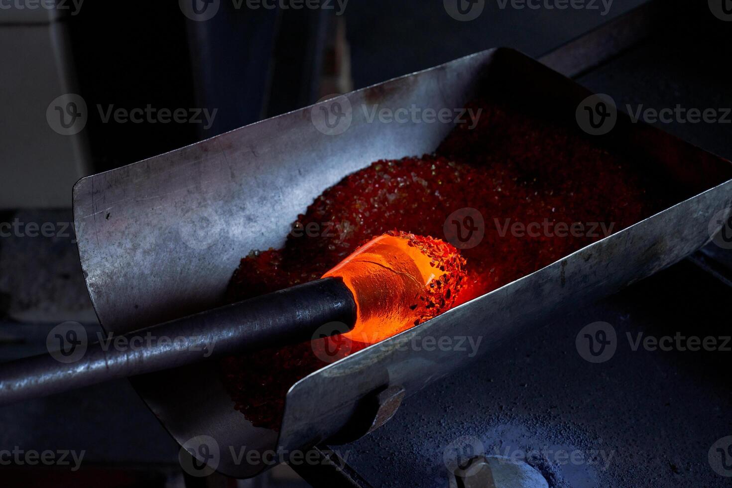 Glassblowing of hot object in workshop photo