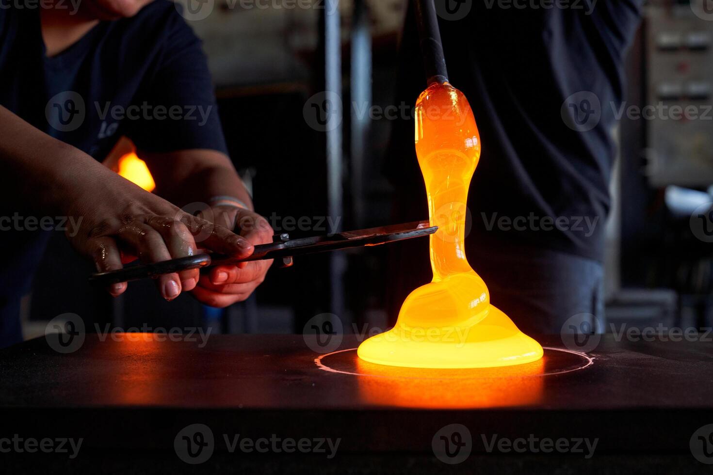 Unrecognizable men cutting liquid glass in workshop photo