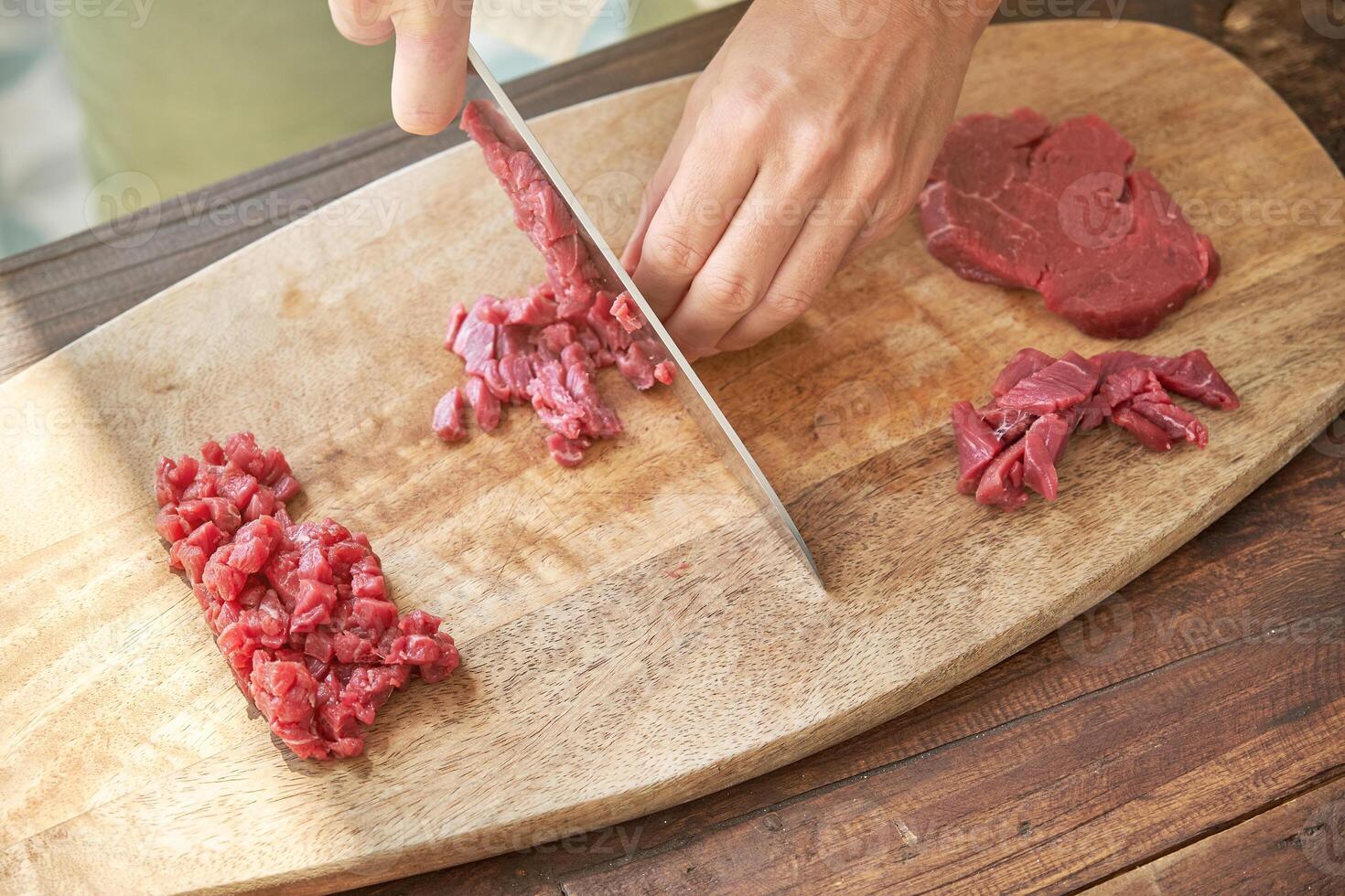 Crop cook chopping meat on wooden board photo