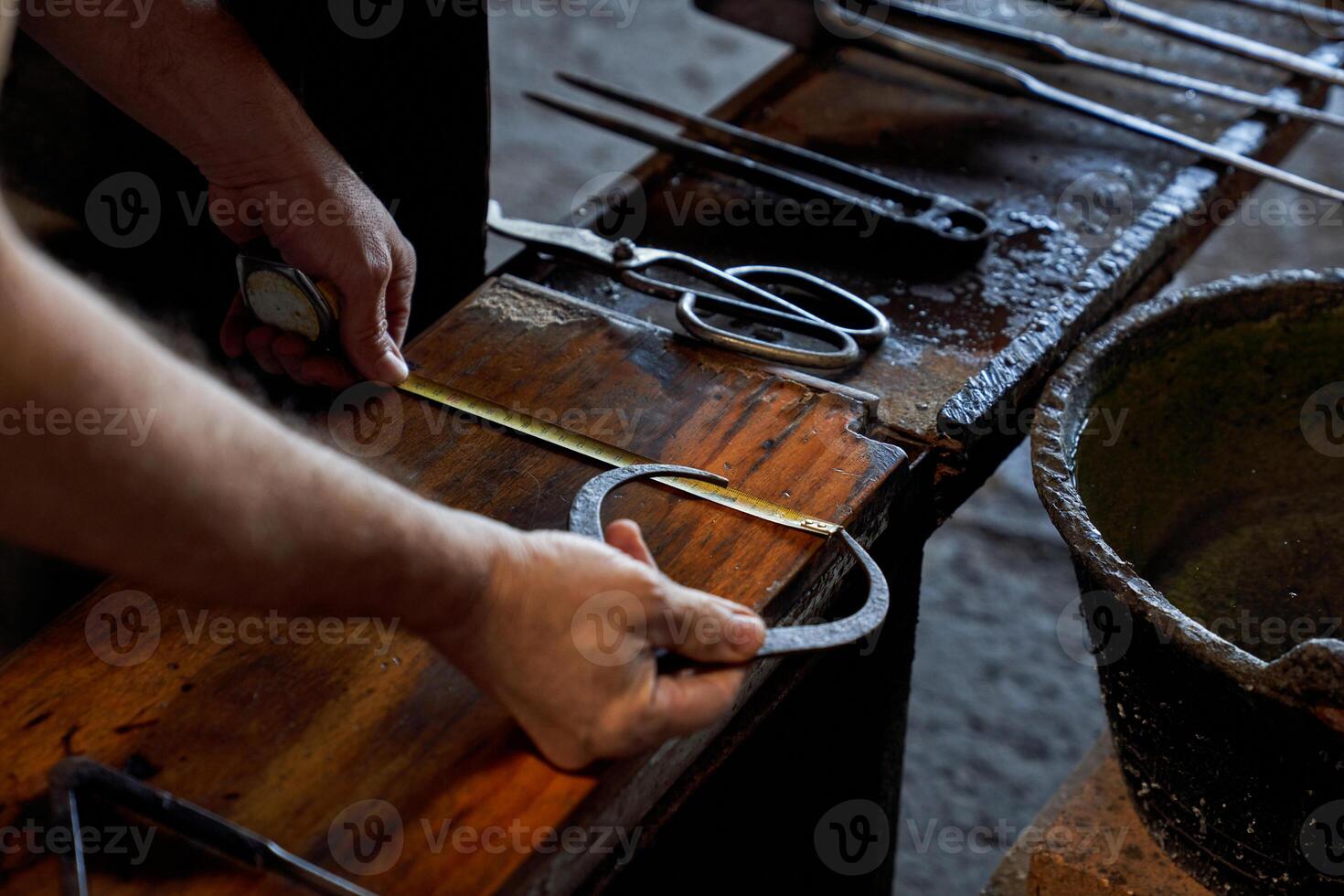 Crop artisan with measuring tape and tool in glass making factory photo