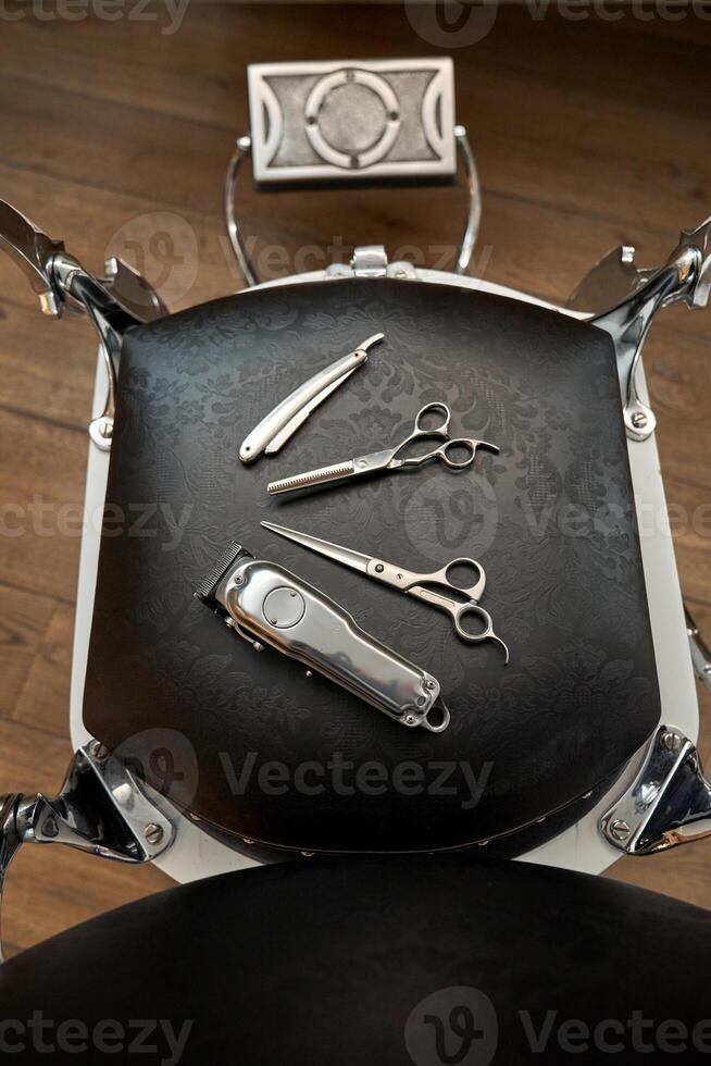 Professional barber tools on leather chair photo