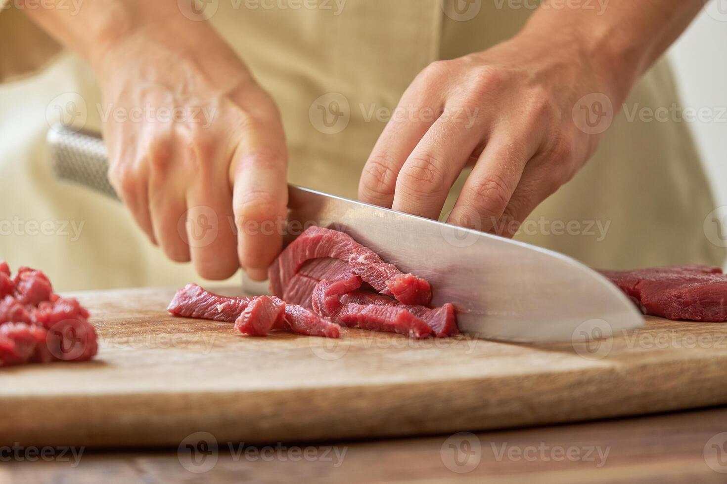 Unrecognizable woman cutting meat on board photo