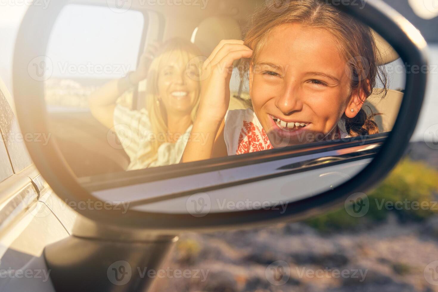 Mirror of a car with the image of a mother and daughter looking photo