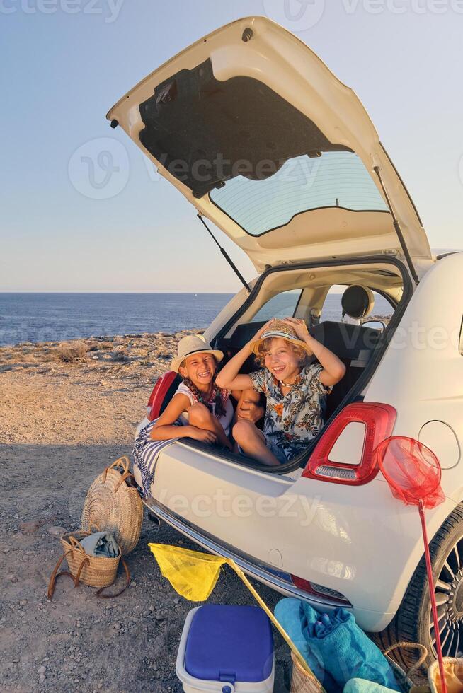Children inside the trunk of a car making joke gestures with bas photo