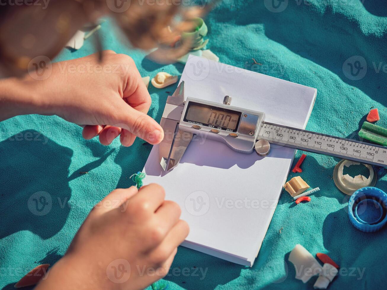 Crop boy preparing measurement of plastic piece with digital cal photo
