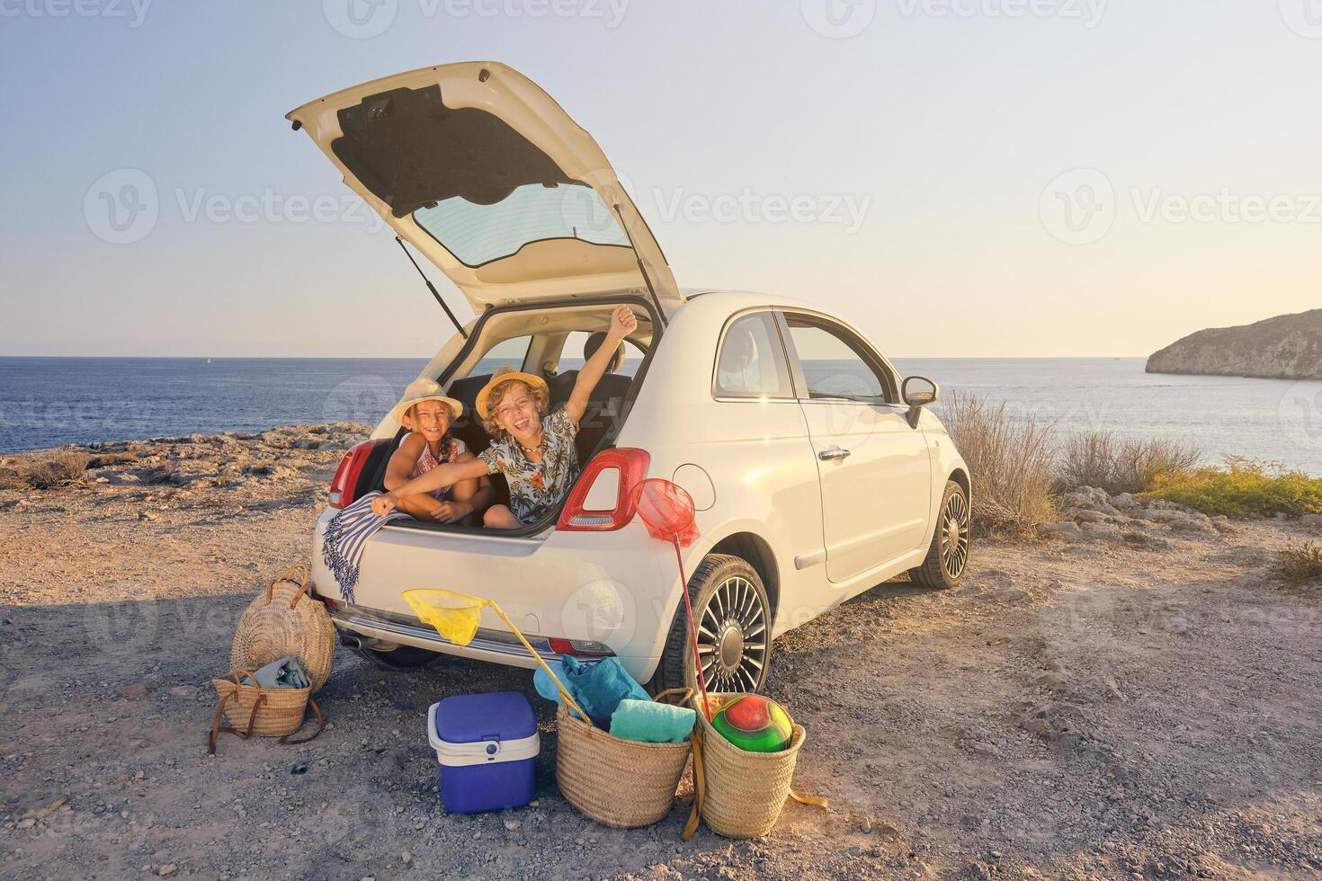 Two children sitting inside the trunk of the car with gestures o photo