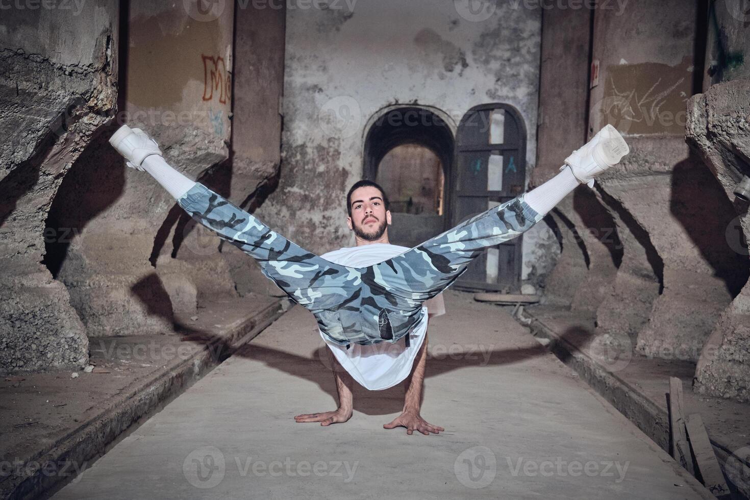 Man dancing break dance in abandoned building photo