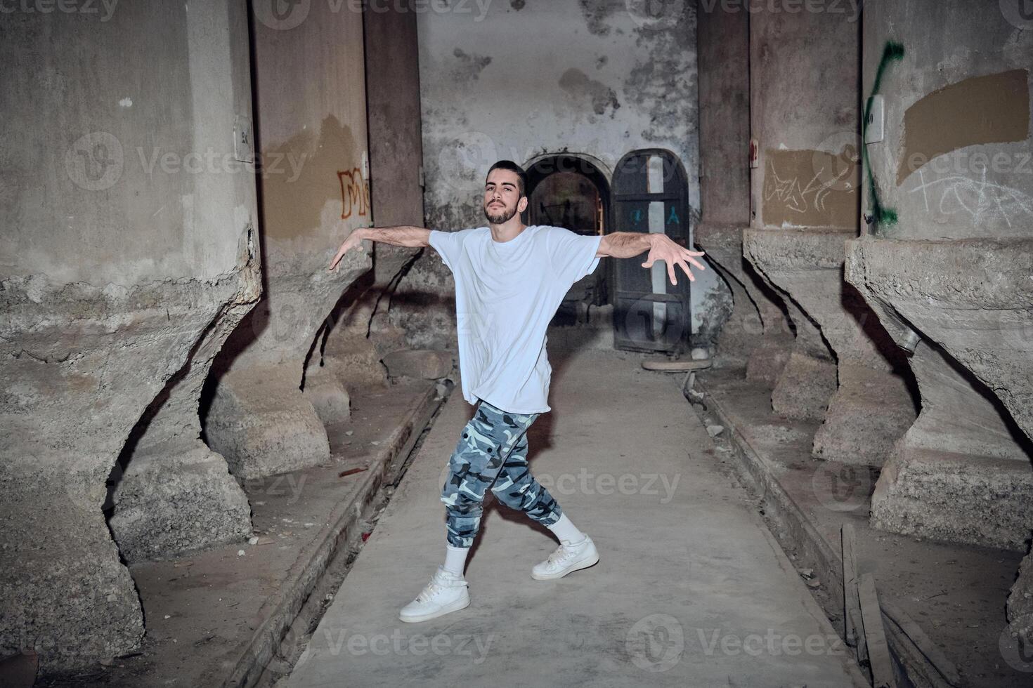 Confident man break dancing in desolated building photo