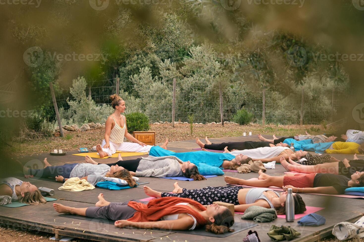 Group of females lying in forest while practicing yoga photo