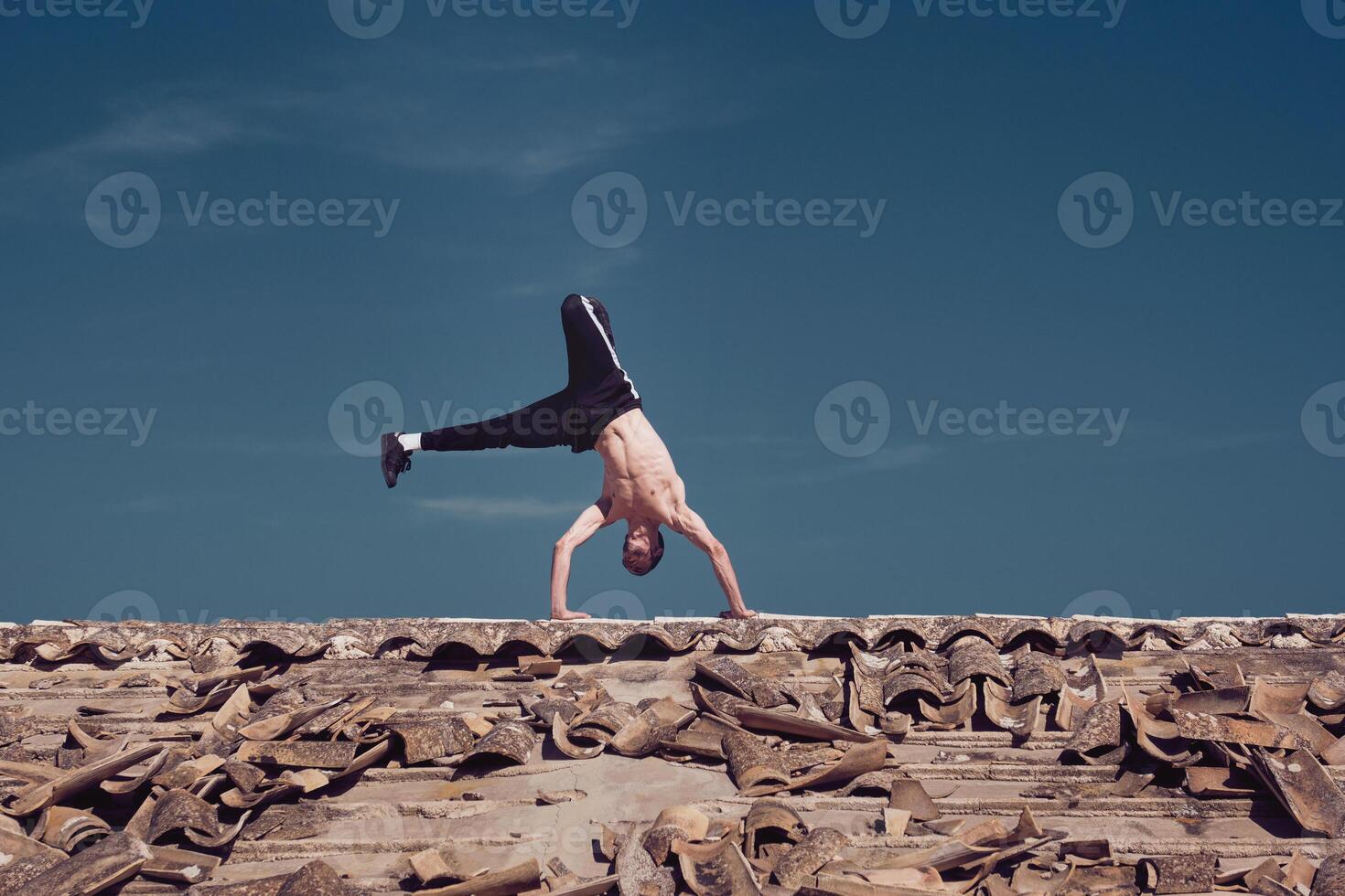 Flexible young man performing two hands rotation while dancing breakdance photo