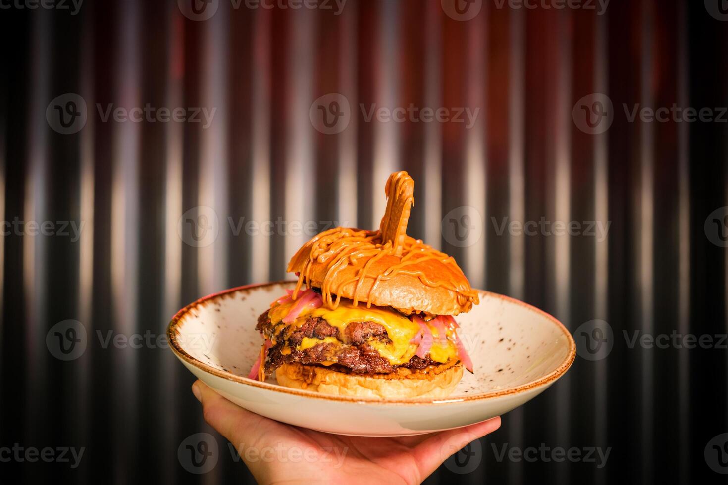 Unrecognizable person with hamburger on plate photo