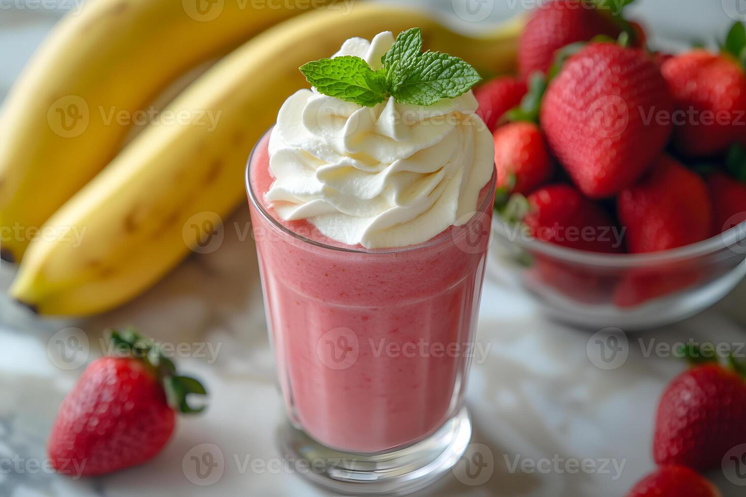 Refreshing strawberry banana smoothie in a clear glass, garnished with whipped cream and a mint sprig for a fruity treat photo
