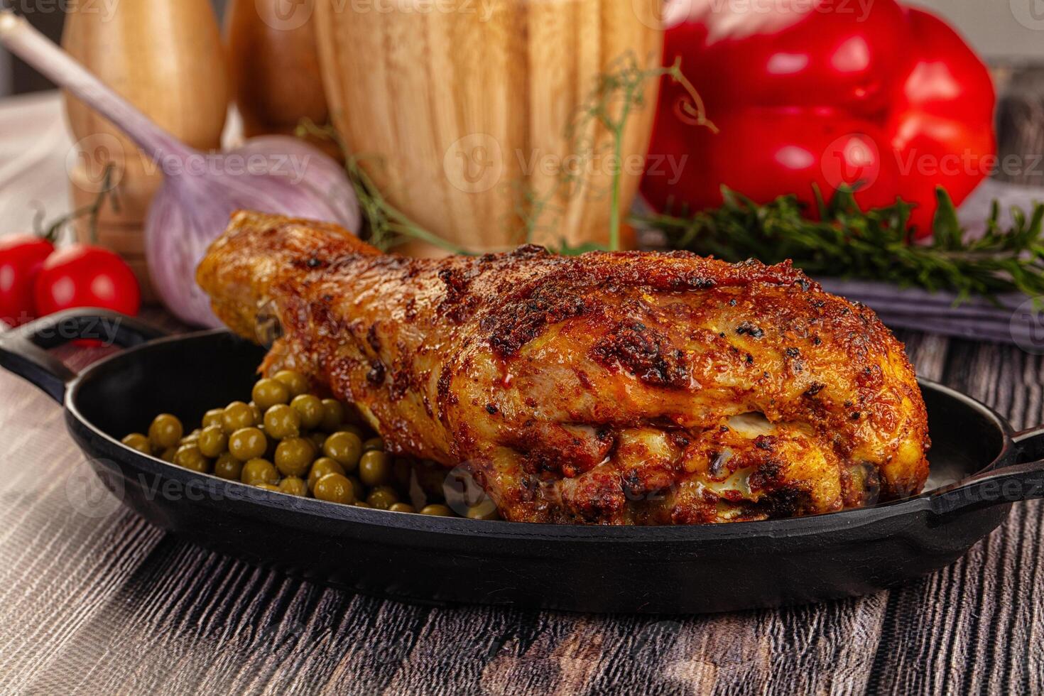 A chicken in a pan with peas and tomatoes photo