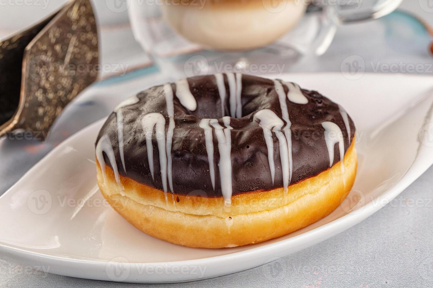 A donut with chocolate icing on a white plate photo
