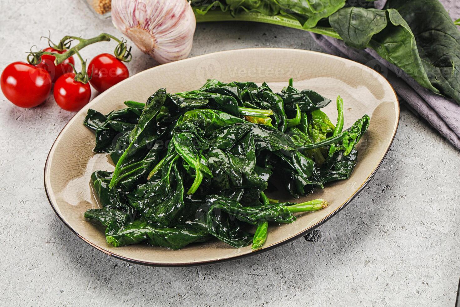 Spinach with garlic and tomatoes on a plate photo