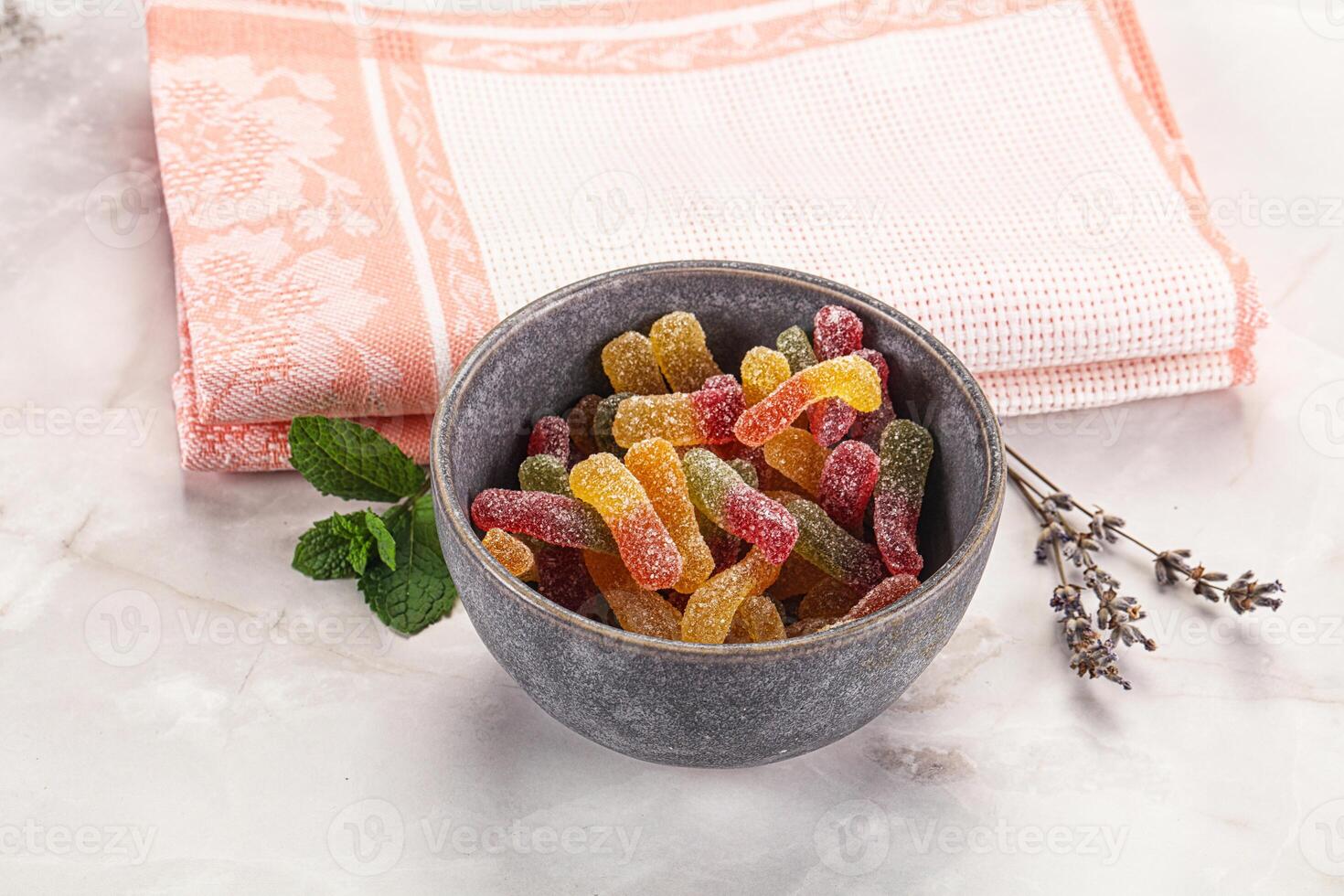 A bowl of fruit gummy bears on a table photo