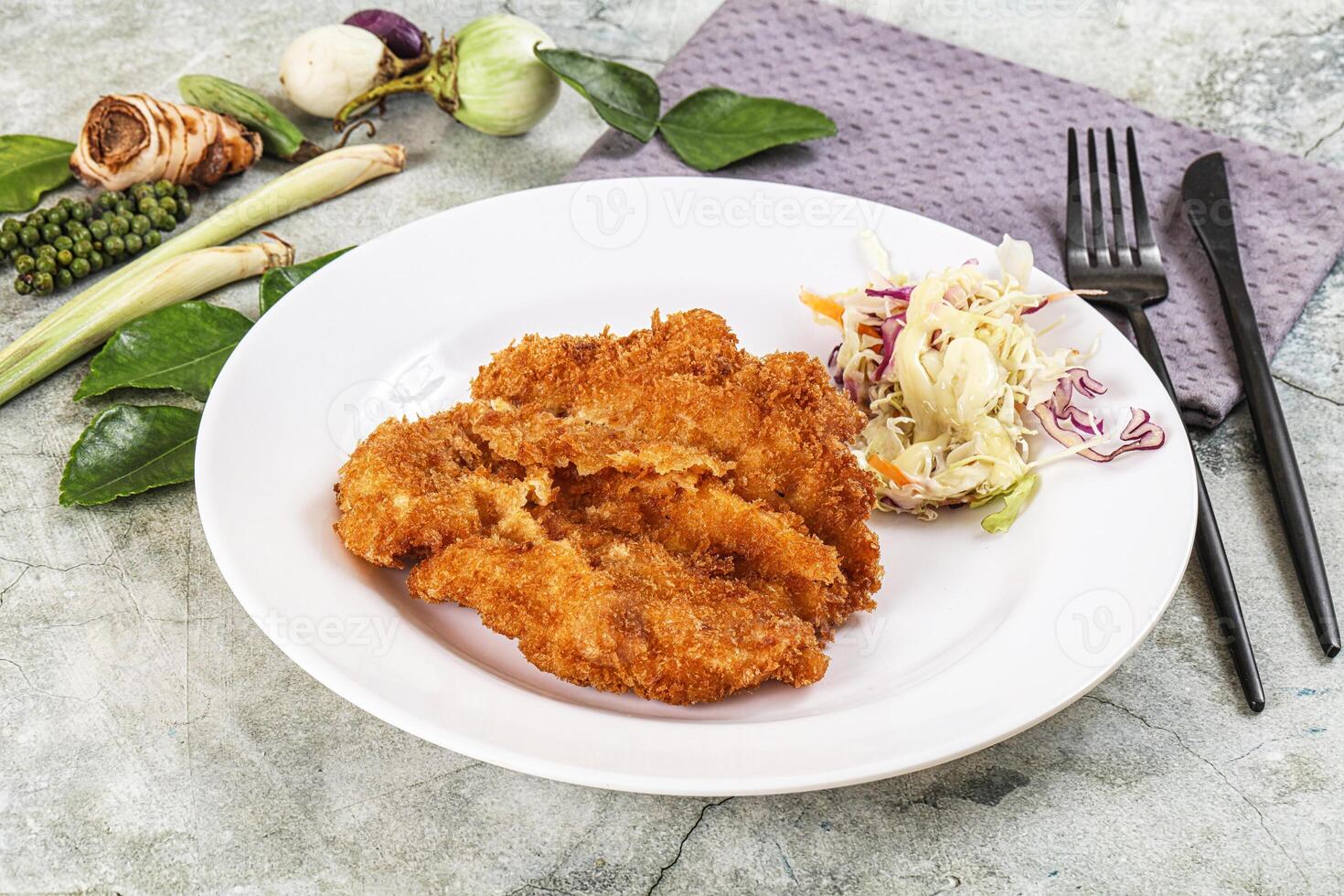 Fried chicken cutlets with coleslaw on white plate photo