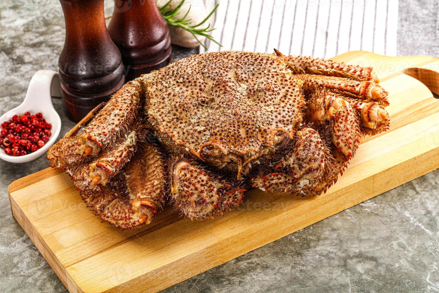 A large crab sitting on a cutting board photo