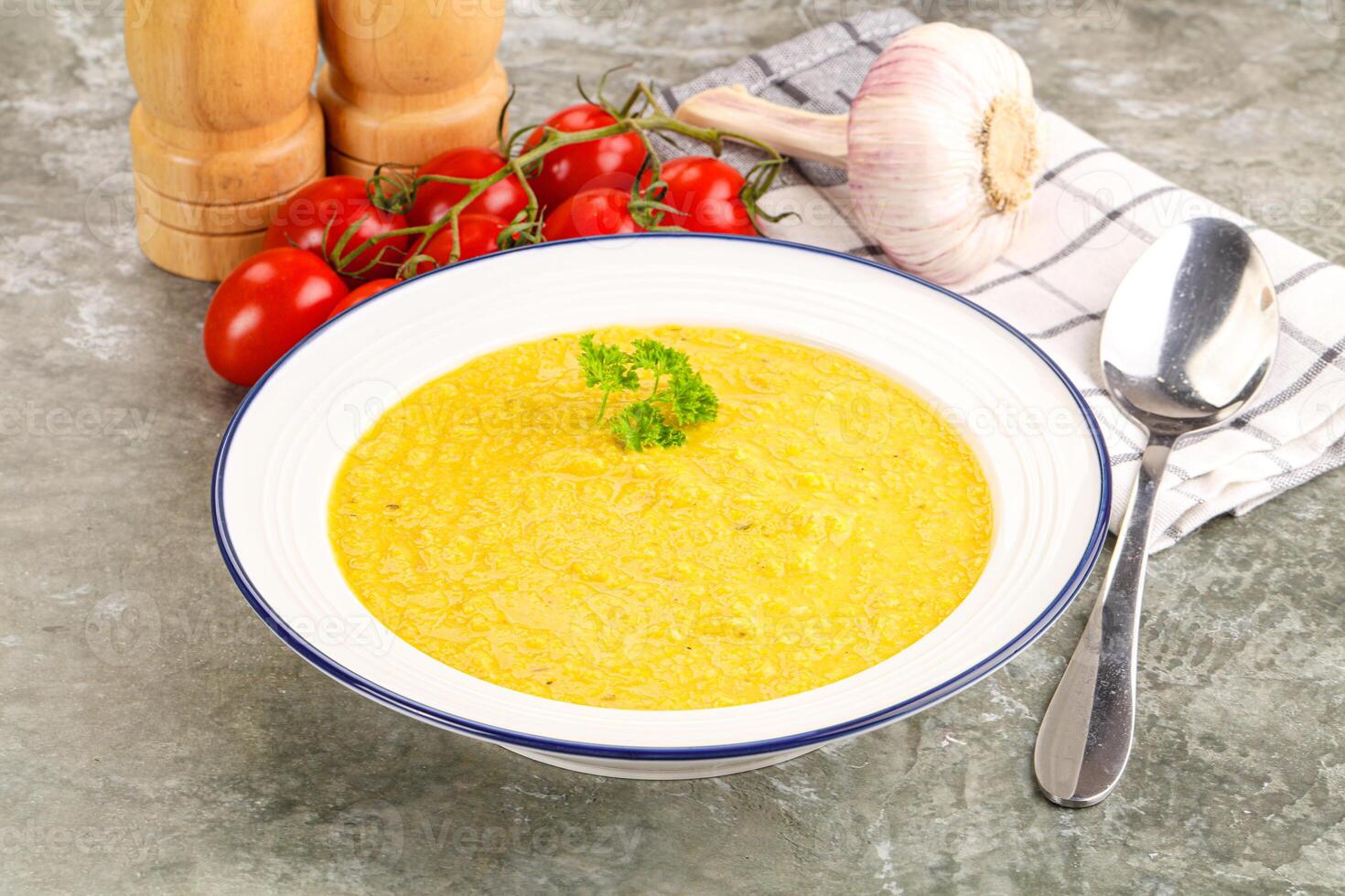 A bowl of soup with a spoon and a knife photo