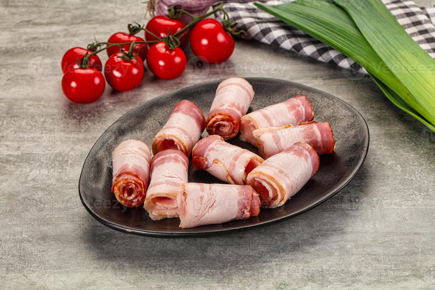 Bacon wrapped in bacon on a plate with tomatoes photo