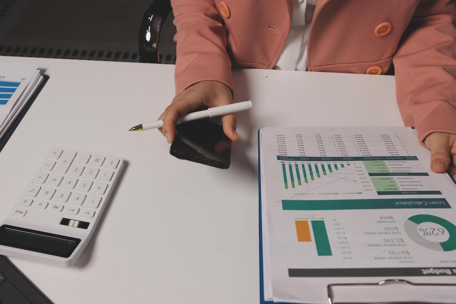 Businesswoman using calculator and pen to calculate photo