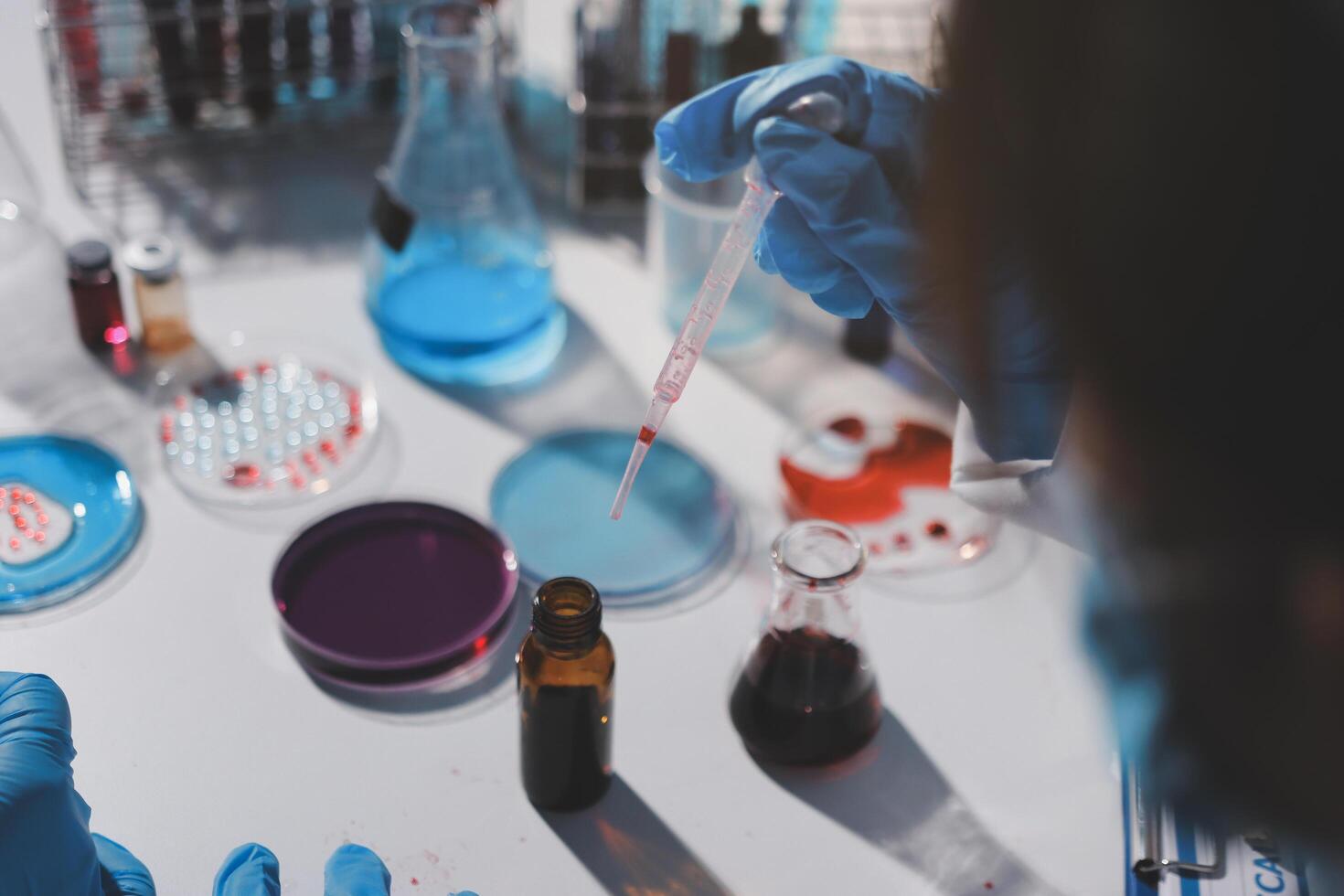 A person in blue gloves is holding a test tube photo