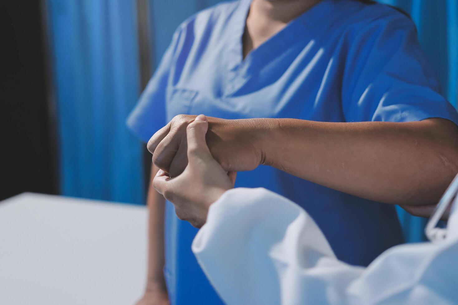 A doctor is holding the hand of a patient photo
