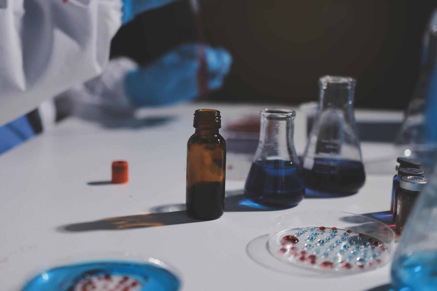 A person in a lab coat is holding a bottle photo