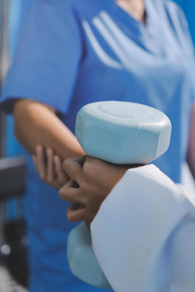 A doctor is holding a dumbbell in front of a patient photo