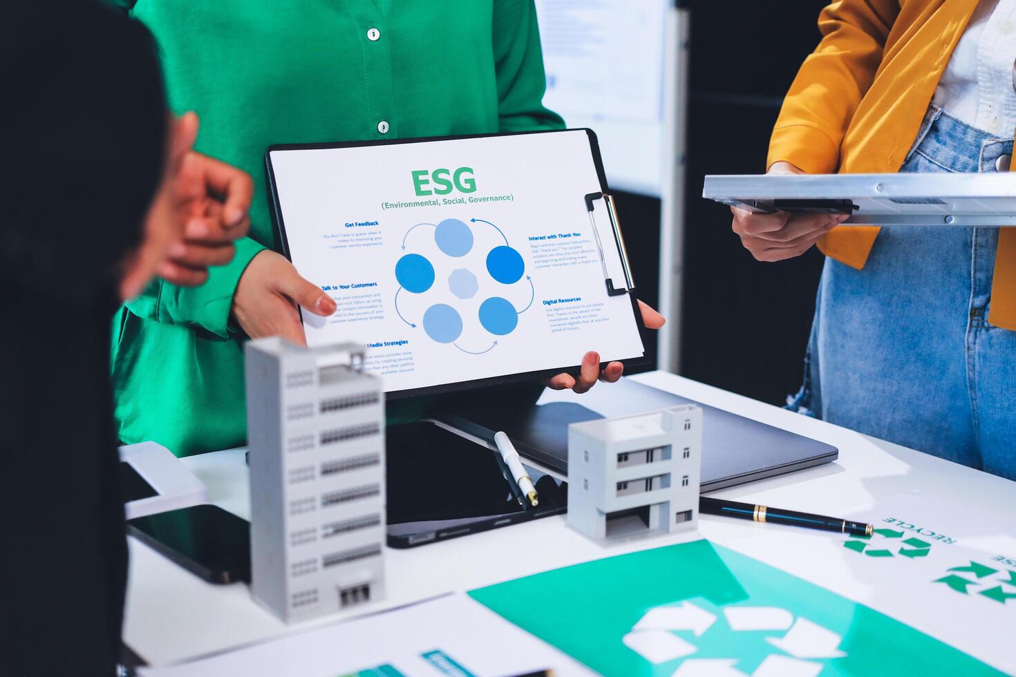 People standing around a table with a green and white board photo