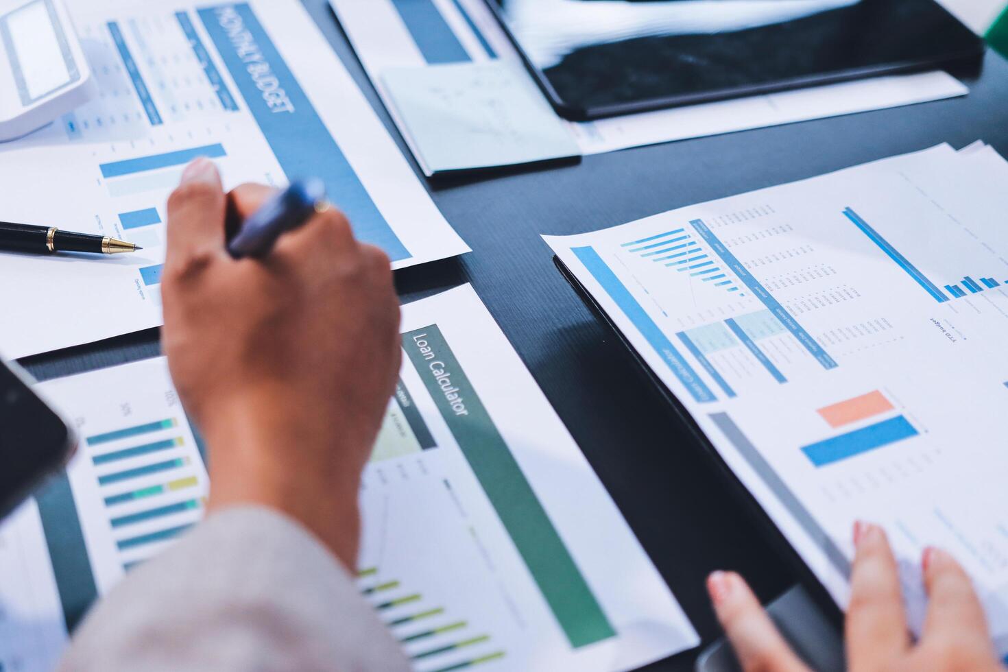 Business people working on papers with graphs and papers photo