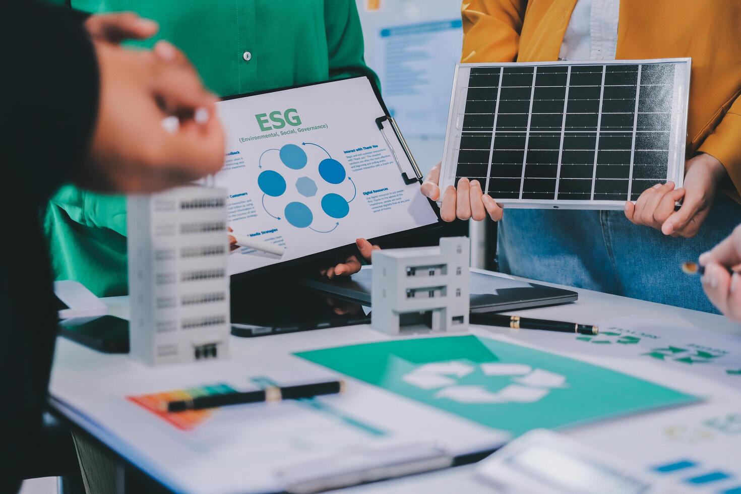 People working on a laptop with a solar panel on it photo