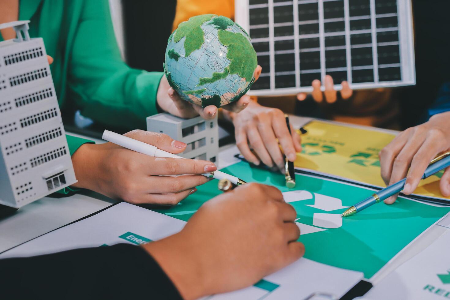 People working on a project with a green globe photo