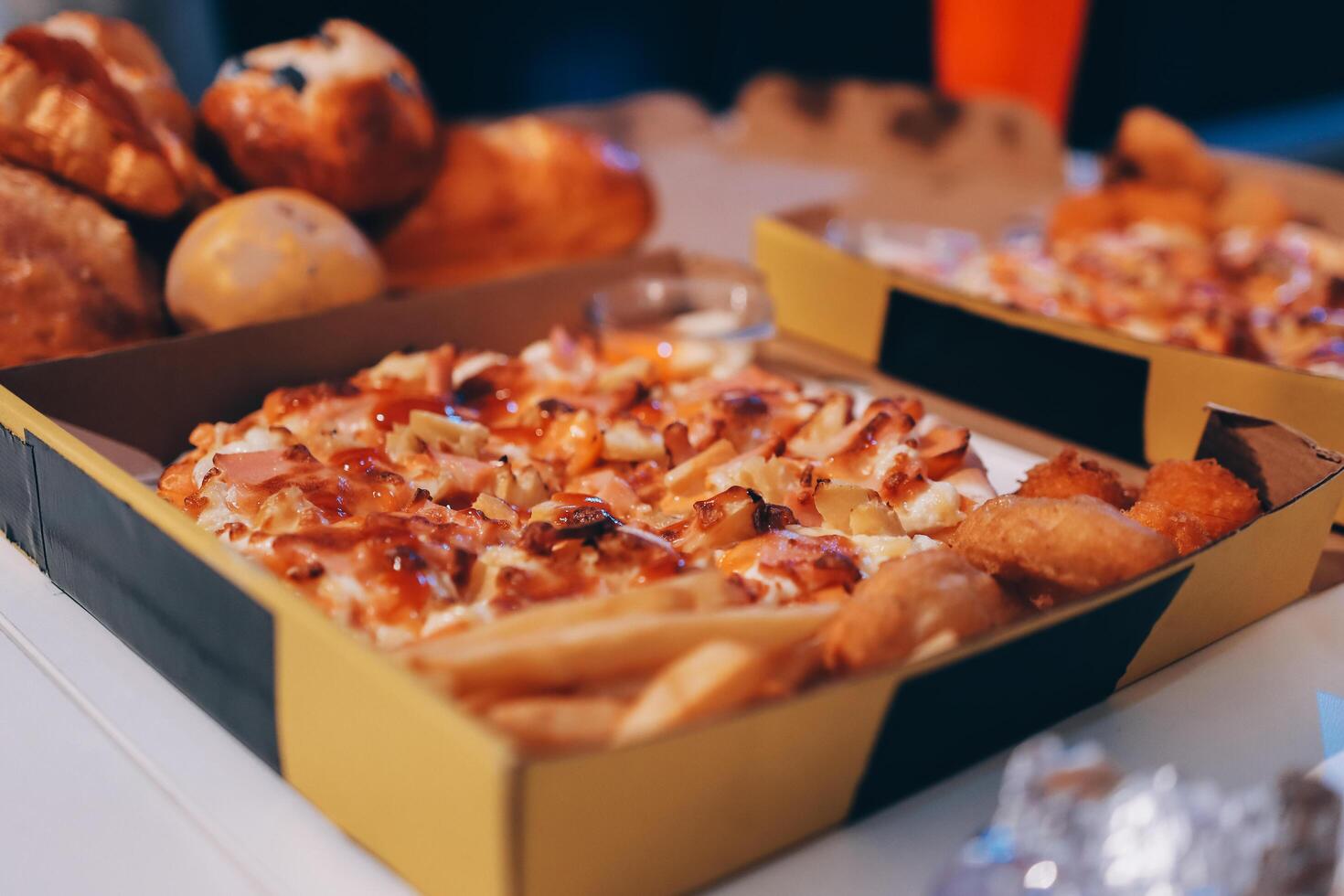 Two boxes of pizza and french fries sitting on a table photo